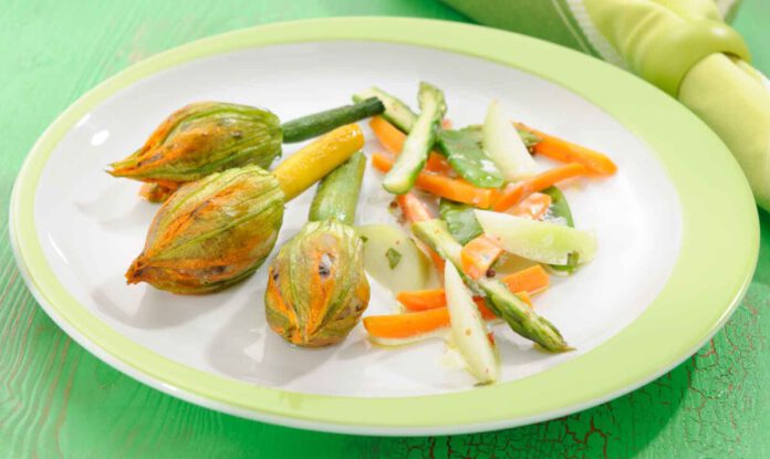 Gefüllte Zucchiniblüten auf Frühlingsgemüse