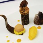 Komposition von der Valrhona Araguani Schokolade und Blumenduftmango