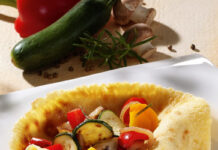Wraps à la Italia (für 4 Personen) Für die Wraps: 125 g Mehl 1 Msp. Backpulver 1/4 l Milch 4 EL Sonnenblumenöl 2 große Eier weißer Pfeffer 1 Prise Salz Für die Füllung: 2 kleine Zucchini 100 g Champignons 1/2 rote Paprikaschote 1/2 gelbe Paprikaschote 2 Zwiebeln 1 Knoblauchzehe Salz Pfeffer Rosmarin Mehl, Backpulver, Milch und Eier zu einem glatten Teig verrühren, leicht pfeffern und salzen und etwa 20 Minuten quellen lassen. In der Zwischenzeit das Gemüse waschen und putzen, die Zwiebeln schälen. Zucchini und Champignons in Scheiben, Paprika in Stücke, die Zwiebeln in Ringe schneiden. Knoblauch abziehen und fein würfeln. In einer mittelgroßen Pfanne 2 EL Öl erhitzen und aus dem Teig 4 gleichgroße Pfannkuchen backen. In einer zweiten Pfanne weitere 2 EL Öl erhitzen, Knoblauch kurz andünsten, das Gemüse zugeben und weitere fünf Minuten dünsten. Mit Salz, Pfeffer und Rosmarin herzhaft würzen. Die Pfannkuchen mit dem Gemüse füllen. Pro Person: 311 kcal (1302 kJ), 11,9 g Eiweiß, 16,3 g Fett, 29,3 g Kohlenhydrate (2,4 BE) Wraps a la Italia Fotohinweis: www.1000rezepte.de